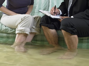 man and woman sitting on couch in flooded house